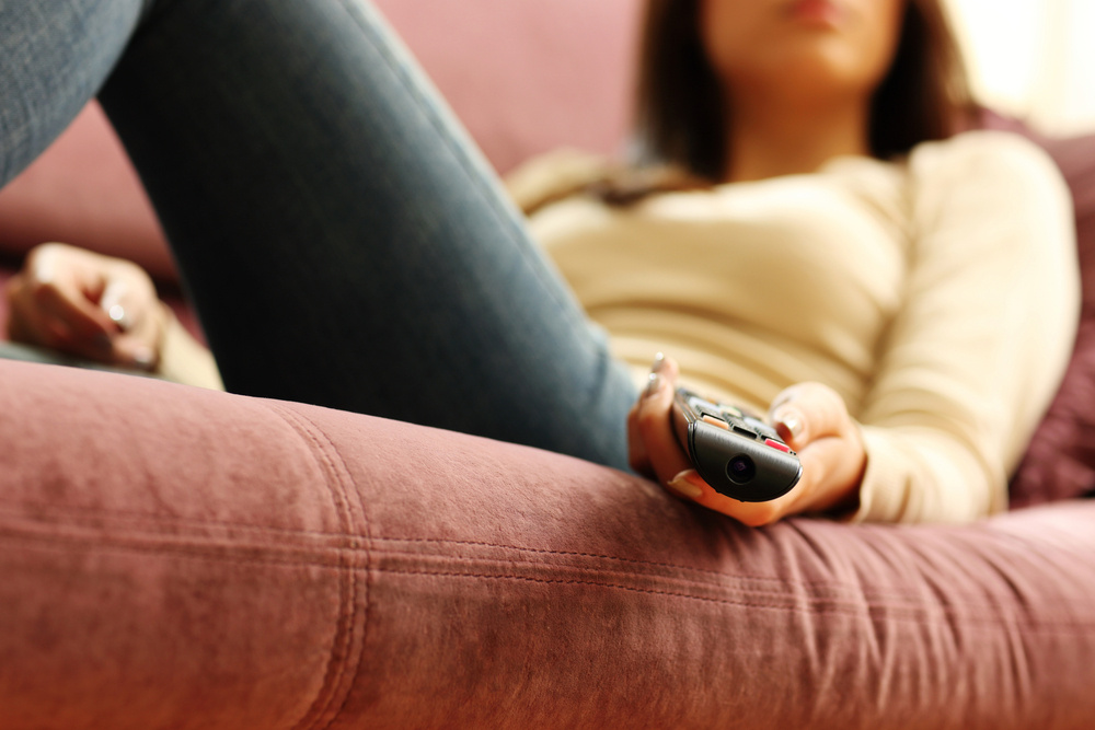 Closeup image of a female hand holding remote control