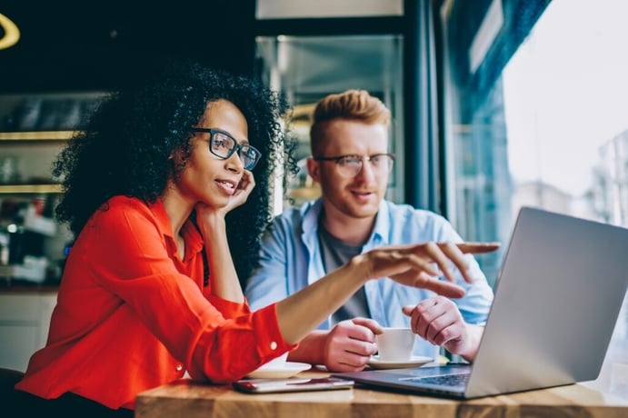 two people staring at laptop screen 