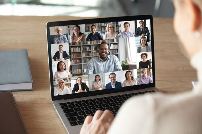 laptop with a video call with several people on the screen 