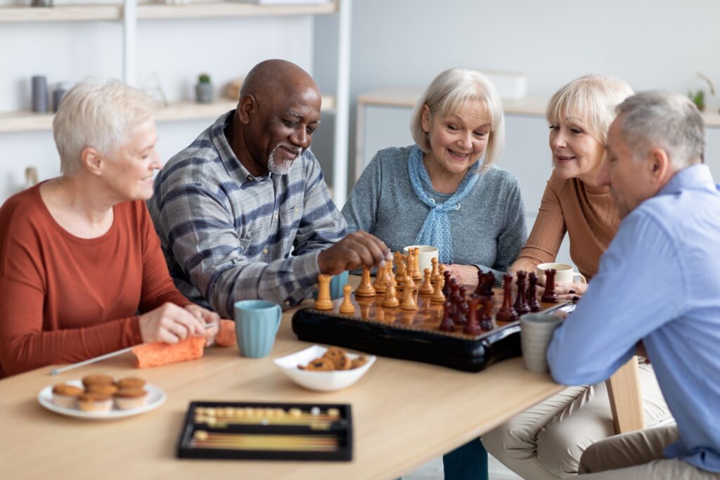 group of seniors playing chess in a senior living facility. 