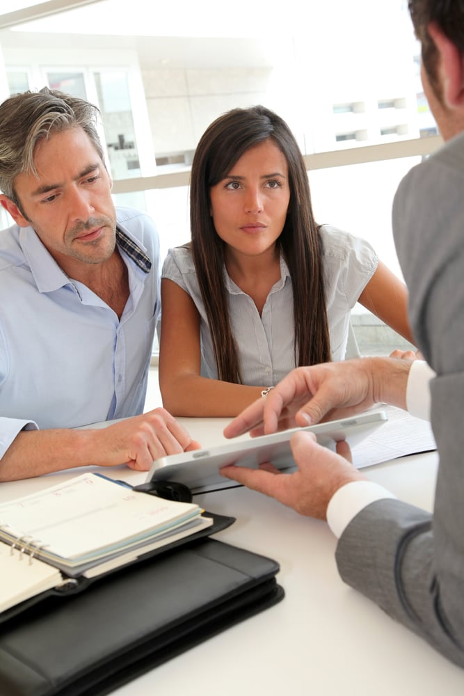 Real-estate agent showing house plans on electronic tablet