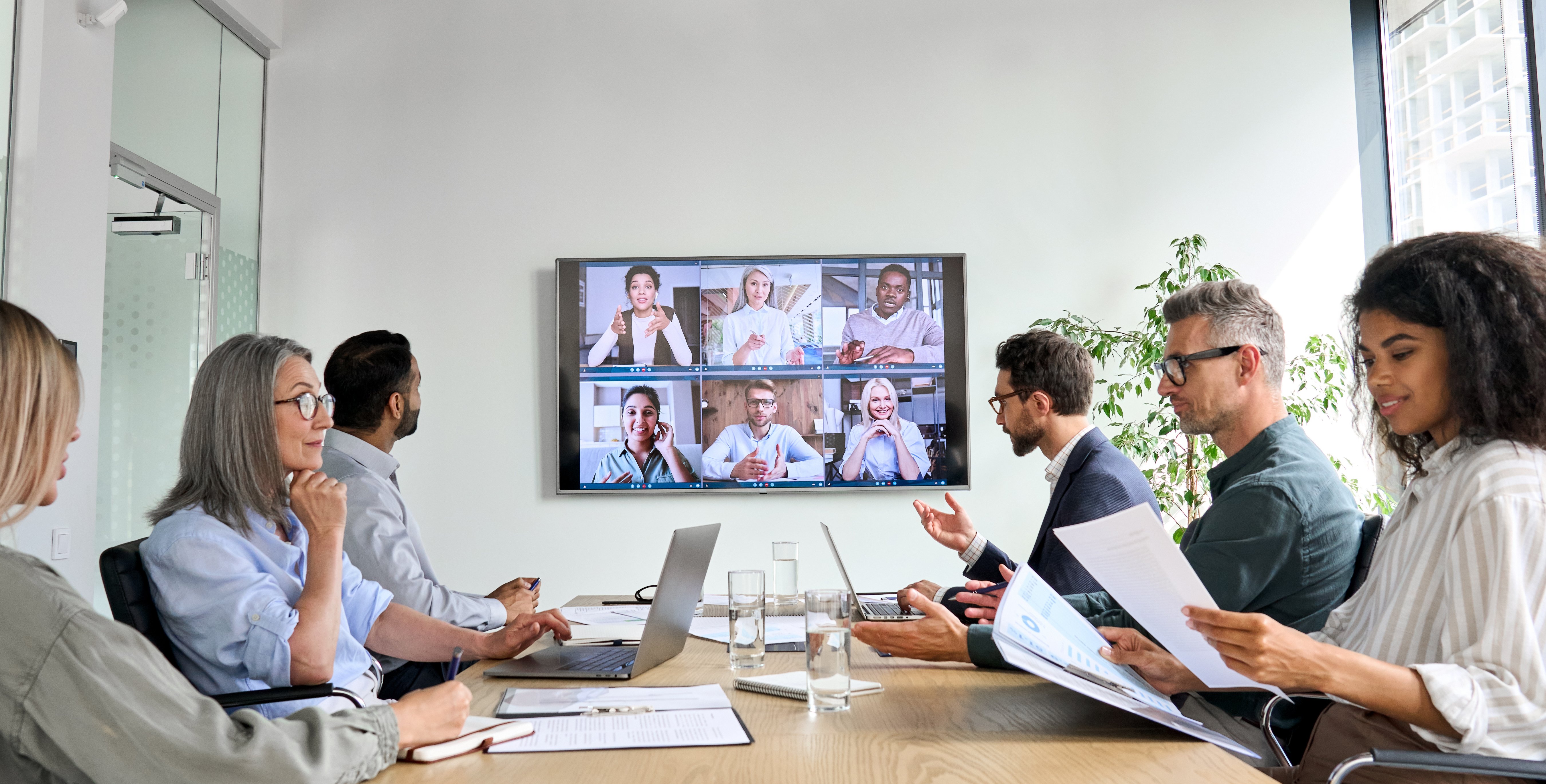 office meeting with screen of virtual attendees