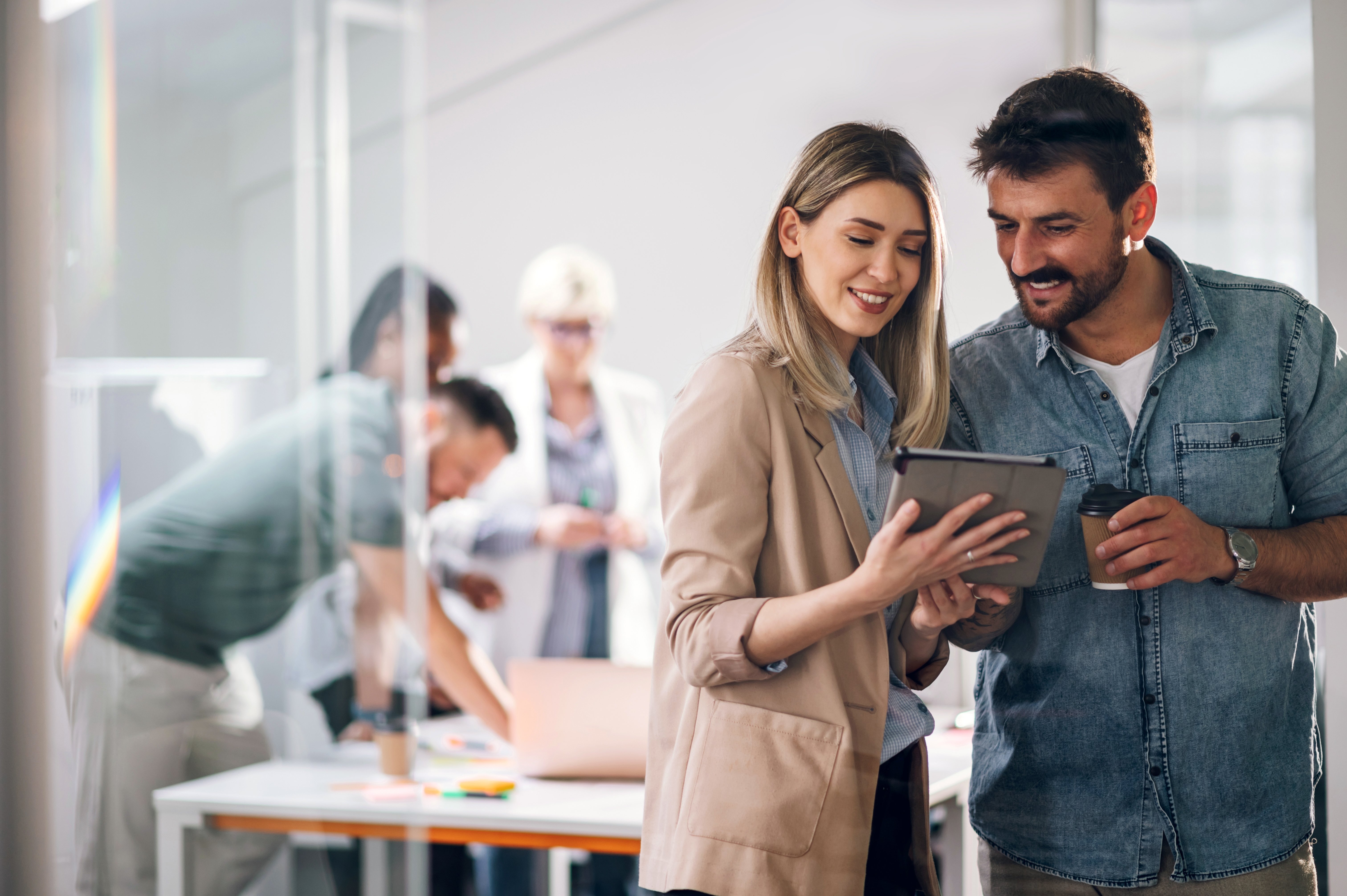 two people looking at a tablet and smiling