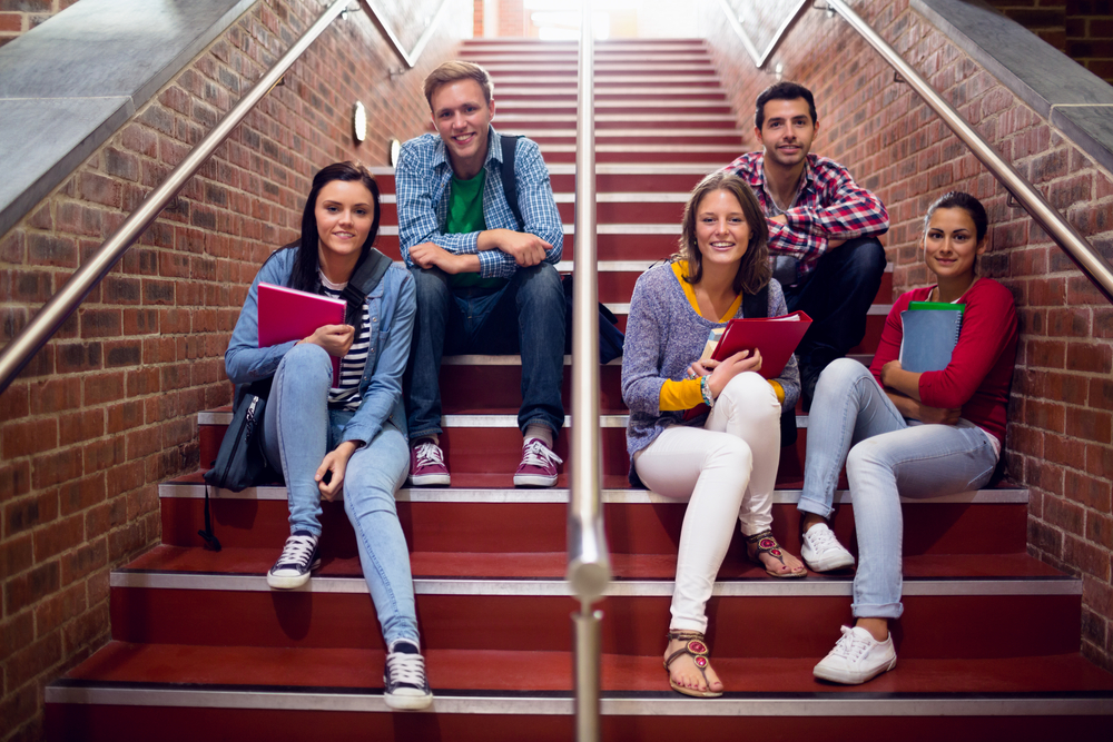 Group portrait of young college students sitting on stairs in the college-1